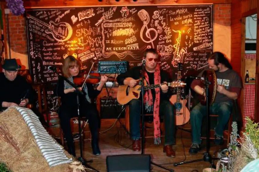 Cuarteto folk con violín, guitarras y bodhrán actuando en la Panadería
