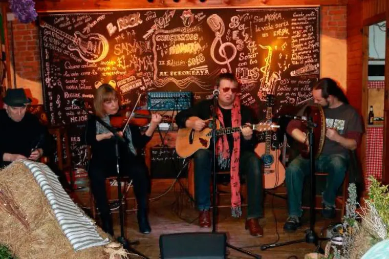 Cuarteto folk con violín, guitarras y bodhrán actuando en la Panadería