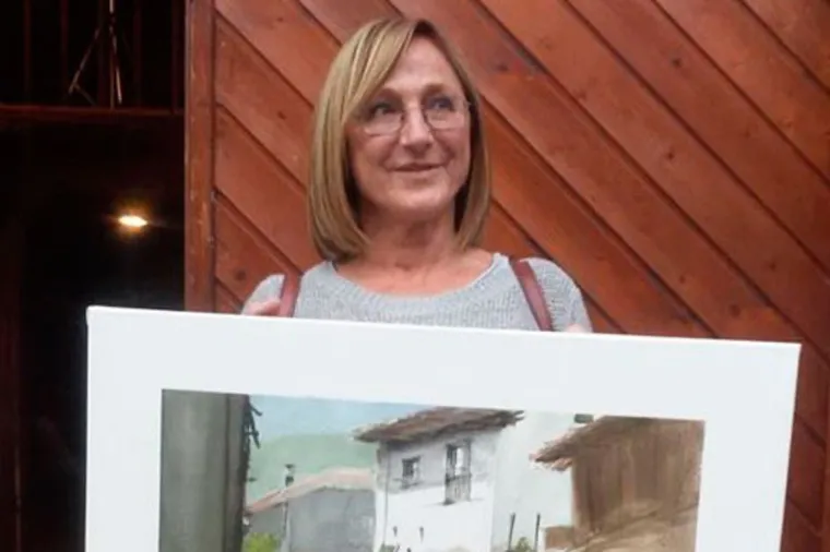 Participante del certamen mostrando su acuarela de una casería asturiana