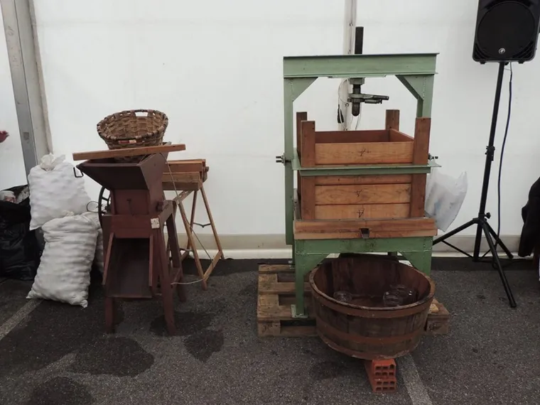 Prensa de sidra tradicional y molino de maíz expuestos en la fiesta