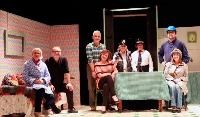 Compañía de teatro saludando sobre el escenario al final de una función