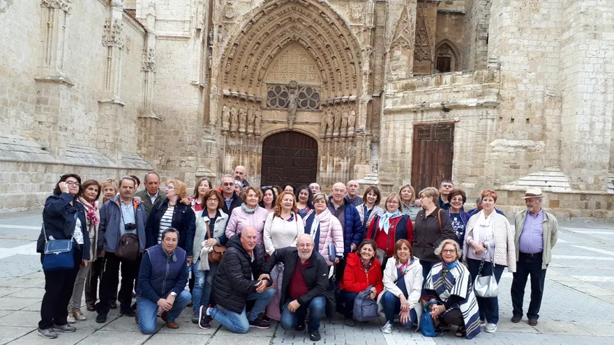 Foto de grupo de los socios ante la portada de una catedral gótica